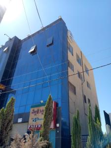 a blue building with a clock on it at Monument Suites in Amman