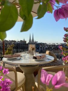 a table on a balcony with a view of a city at H&ocirc;tel Singulier Bordeaux in Bordeaux