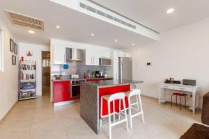 a kitchen with a red island in a room at Skyline by Zama Homes in Playa del Carmen