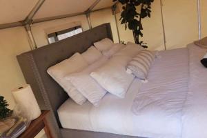 una cama con almohadas blancas en una habitación en The Raven Lounge, en Delta