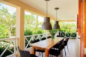 een veranda met een houten tafel en stoelen bij Villa Diana in Las Galeras