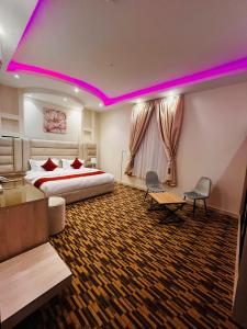a hotel room with a bed and purple lighting at شقق الروشن الجوفي in Al Fayşalīyah