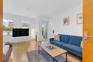 sala de estar con sofá azul y TV en WINETIME - für 3 - nähe Madenburg - Burg Landeck, en Eschbach