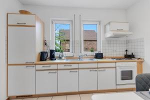 a kitchen with white cabinets and a sink at WINETIME - für 3 - nähe Madenburg - Burg Landeck in Eschbach