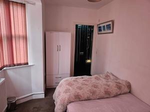 1 dormitorio con 1 cama, vestidor y nevera en Available rooms at Buckingham road en Doncaster