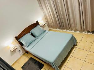 Un dormitorio con una cama con almohadas azules. en Blue Home2 T3 meublé à Matoury pour 1 à 6 voyageurs., en Matoury