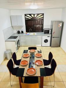 una cocina con mesa y sillas y una cocina con en Blue Home2 T3 meublé à Matoury pour 1 à 6 voyageurs., en Matoury