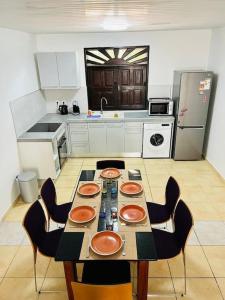 a kitchen with a table and chairs and a kitchen with at Blue Home2 T3 meublé à Matoury pour 1 à 6 voyageurs. in Matoury +4 photos