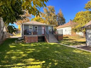 a house with a porch and stairs in a yard at Retro bungalow workspace fast WiFi in Louisville