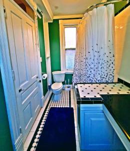 a small bathroom with a toilet and a shower at Point Breeze Guest House in Pittsburgh