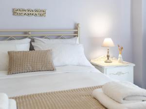 a bedroom with a white bed with a lamp on a table at 4keys House - Apartment 4 in Tripoli