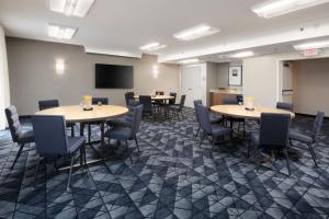 a conference room with tables and chairs and a screen at Courtyard by Marriott Dallas Plano Parkway at Preston Road in Plano