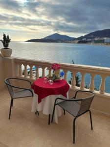 una mesa y sillas en un balcón con agua en Hotel Kuč en Budva