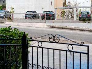 an iron fence with cars parked in a parking lot at 4keys House 4 in Tripoli