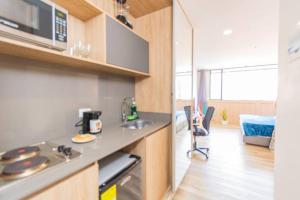 een keuken met een aanrecht en een fornuis bij Bright Studio Topfloor A/C, Poblado Coworking1412 in Medellín +7 foto's