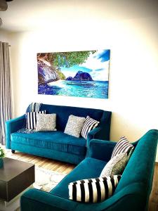 um sofá azul numa sala de estar com um quadro em Quiet Nest Homes em Tatu City