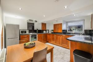 a kitchen with wooden cabinets and a wooden table at Sleek 2B/1B Retreat in Lindley, Huddersfield in Lindley