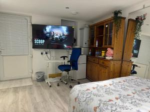 Schlafzimmer mit einem Bett und einem Flachbild-TV in der Unterkunft North Avenue, Guest House, Heathrow Airport-Free Parking in Hayes