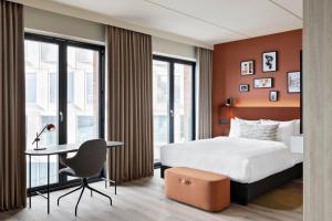 a hotel room with a bed and a desk and a table at Residence Inn by Marriott Copenhagen Nordhavn in Copenhagen