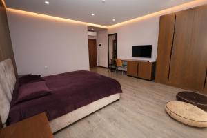Dormitorio con cama, escritorio y TV en Rezidenca Arlington en Berat
