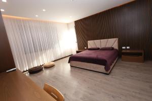 a bedroom with a bed and a table in a room at Rezidenca Arlington in Berat