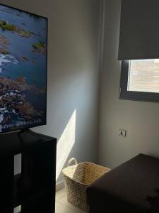 sala de estar con TV de pantalla plana en la pared en Casa de Manu, en Rodas