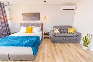 une chambre avec un lit, un canapé et une chaise dans l'établissement Poblado, Modern studio, coworking, A/C, Gym 1411, à Medellín