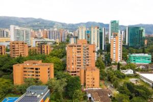 een skyline van de stad met hoge gebouwen en bomen bij Poblado, Modern studio, coworking, A/C, Gym 1411 in Medellín