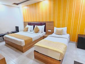 a hotel room with two beds and a flat screen tv at Hotel EnCasa Stay Near International Airport in New Delhi
