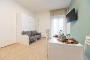 a kitchen and living room with a couch and a table at B&B Porta del Salento in Brindisi