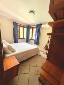 een slaapkamer met een bed met blauwe gordijnen bij Apartamento Sogno D' Estate in Porto Seguro