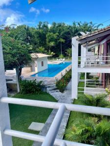 uitzicht op het zwembad vanaf het balkon van een huis bij Apartamento Sogno D' Estate in Porto Seguro