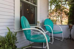 dos sillas verdes sentadas en el porche de una casa en Retro Bungalow en Santa Rosa