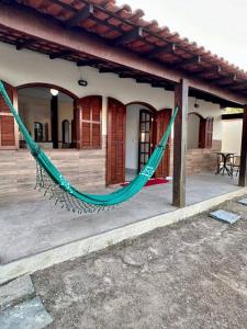 a green hammock on a porch of a house at Casa Completa, muito bem localizada ! in Búzios