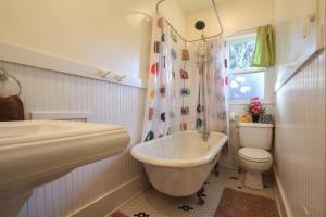 a bathroom with a tub and a toilet and a sink at Retro Bungalow in Santa Rosa