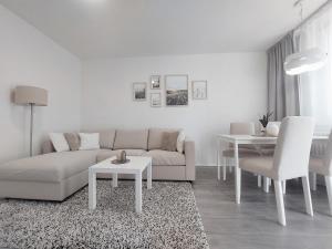 a white living room with a couch and a table at Komfortní byt Pod Příčnou in Zlaté Hory
