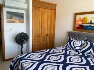 1 dormitorio con 1 cama con edredón azul y blanco en Apartamentos Penon del Rodadero, en Santa Marta