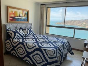 聖瑪爾塔的住宿－Apartamentos Penon del Rodadero，一间卧室设有一张床,享有海景