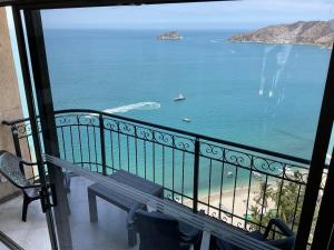 un balcón con un banco y vistas al océano en Apartamentos Penon del Rodadero, en Santa Marta