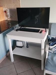 un monitor de ordenador en un escritorio blanco con teclado en Bay Breeze, en Reebok