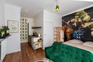 um quarto com um sofá verde e uma pintura na parede em Suite Grand Cru - SPA & terrasse em Arveyres