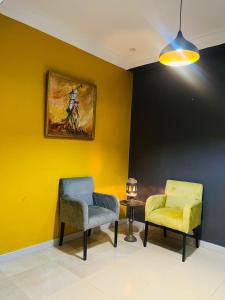 una habitación con 2 sillas y un cuadro en la pared en Villa le jasmin en Oulad Bou Abdallah