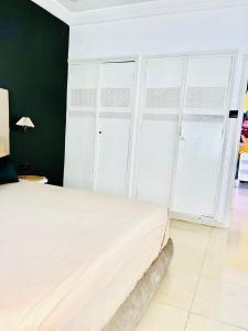 Villa le jasmin في Oulad Bou Abdallah: غرفة نوم بسرير بأبواب بيضاء