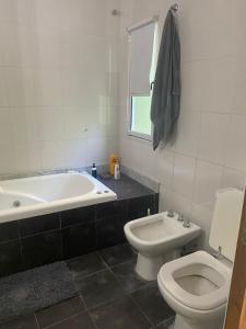 a bathroom with a tub and a toilet and a sink at La josefina in Villa María