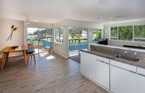 a kitchen with white cabinets and a view of a pool at Heart of town in Coromandel Town