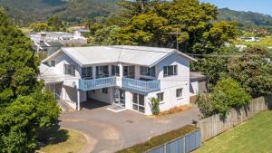 an aerial view of a white house with a blue roof at Heart of town in Coromandel Town