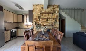 a kitchen and dining room with a wooden table and chairs at Villa Bellissimo in Skala Potamias +55 photos