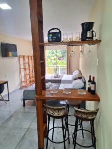 a room with a table with chairs and a bed at Suítes Recanto Petrópolis in Petrópolis