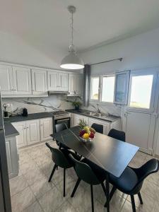 a kitchen with a table and chairs in a kitchen at Aeolian Breeze 2 in Tinos