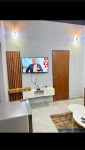 a living room with a flat screen tv on a wall at Sanyiri meublée in Ouagadougou